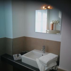 een badkamer met een witte wastafel en een spiegel bij Wachtendonker Hof in Wachtendonk