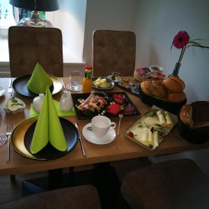 a wooden table with plates of food on it at Wachtendonker Hof in Wachtendonk