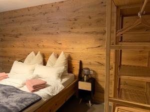 Cama en habitación con pared de madera en Top Apartment in Zentrumsnähe (Fußläufig), en Schwaz