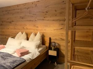 a bed in a room with a wooden wall at Top Apartment in Zentrumsnähe (Fußläufig) in Schwaz