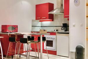 a kitchen with red cabinets and a table with stools at In the heart of Grenoble #CO in Grenoble