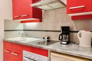 a kitchen with red cabinets and a sink at In the heart of Grenoble #CO in Grenoble