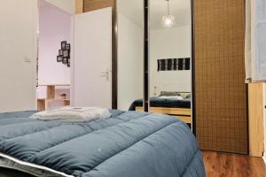 a bedroom with a large blue bed and a mirror at In the heart of Grenoble #CO in Grenoble