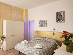 a small bedroom with a bed and a cabinet at Hotel Il Ponte in Cecina