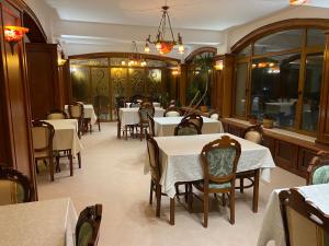 um restaurante com mesas e cadeiras e um lustre em Chalet Wiese em Poiana Brasov