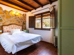 een slaapkamer met een bed en een stenen muur bij Cortijo rincón del sur in Nigüelas +25 foto's