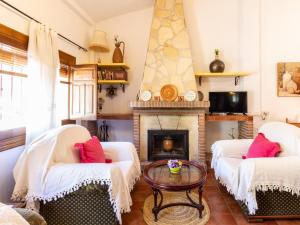 een woonkamer met twee stoelen en een open haard bij Cortijo rincón del sur in Nigüelas