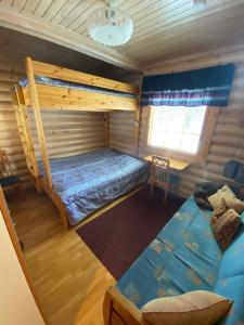 a bedroom with a bunk bed and a couch at Luoston Väärtin Kammi in Luosto