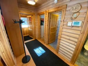 a cabin hallway with a door and a floor vacuum at Luoston Väärtin Kammi in Luosto