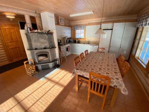 a kitchen and dining room with a table and a fireplace at Luoston Väärtin Kammi in Luosto