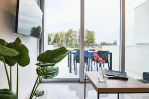 a room with a table and some plants and a window at Phaedrus Living - Seaside Luxury Flat Harbour 102 in Paphos City +7 photos