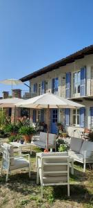 a group of chairs and an umbrella in front of a building at Cascina Giardini in Alba