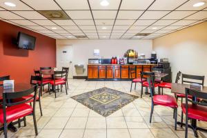 a restaurant with tables and chairs and a kitchen at OYO Hotel LSU in Port Allen