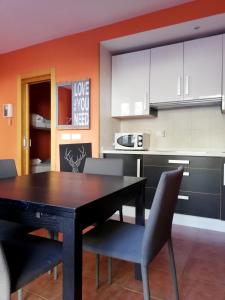a kitchen with a dining room table and chairs at Apartamentos Monte Gorbea con parking y WiFi by SURYNIEVE in Sierra Nevada