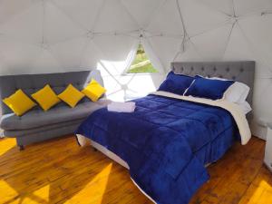 a bedroom with a bed and a couch in a tent at Glamping Amaru in Guatavita