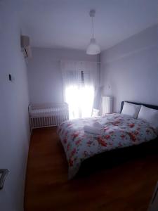 ein Schlafzimmer mit einem Bett mit einer Blumendecke und einem Fenster in der Unterkunft Maklen in Athen