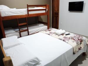 a bedroom with two bunk beds and a television at Hotel Brio in Salinópolis