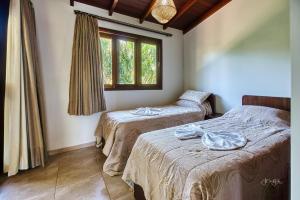 a bedroom with two beds and a window at Unidades Vilas Triplex no Pipa Beleza in Pipa +89 photos