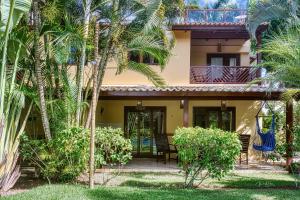 a house with palm trees in front of it at Unidades Vilas Triplex no Pipa Beleza in Pipa