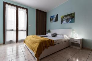 a bedroom with a bed with a yellow blanket on it at Jolie Maison - Smart Holiday in San Giorgio Di Mantova