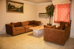 a living room with two couches and a table at Hotel Posada del Sol Inn in Torreón