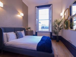 a bedroom with a bed with a large window at Thames Residences Hyde Park in London