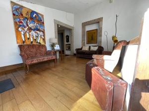 ein Wohnzimmer mit Sofas und einem Wandgemälde in der Unterkunft Rectoral de Cines in Oza dos Ríos