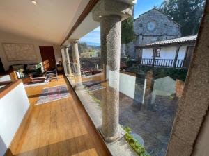 vistas a una casa con una gran ventana de cristal en Rectoral de Cines, en Oza dos Ríos