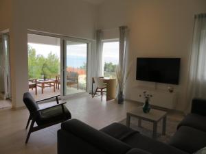 ein Wohnzimmer mit einem Sofa und einem Flachbild-TV in der Unterkunft Korčula - apartman 1, Prigradica - IVAN in Blato