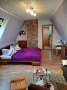 GarzにあるFerienwohnung Garzの屋根裏に紫色のベッドが備わるベッドルーム1室が備わります。