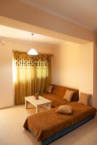 Sala de estar con 2 camas y mesa en Tsoutsis Apartments, en Marantochori