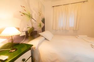 um quarto com uma cama e uma mesa com um candeeiro em Casa de las Flores Cazorla em Cazorla