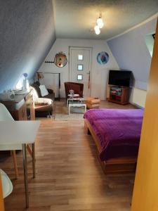 GarzにあるFerienwohnung Garzのベッドルーム(紫色のベッド1台付)、リビングルーム
