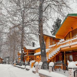 a log cabin in the snow with snow covered benches at Apartments Mizo in Ohrid
