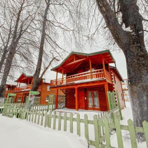 a wooden house with a fence in the snow at Apartments Mizo in Ohrid