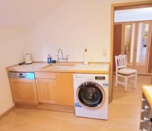 a kitchen with a washing machine and a sink at Piratennest Nord in Bordelum