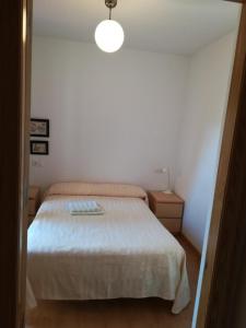 Dormitorio pequeño con cama y luz en Los Tejos, en Riópar