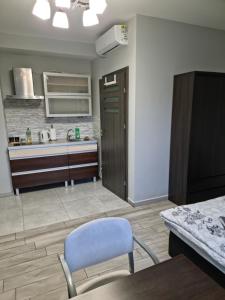 a kitchen with a table and a blue chair in it at Noclegi 24/h Leszczynek in Kutno +3 photos