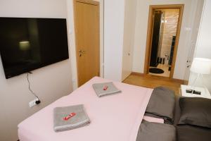 Postel nebo postele na pokoji v ubytování Lusso Apartman