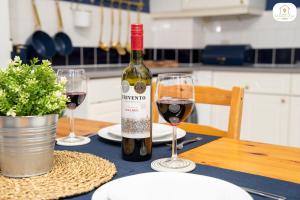 una botella de vino sentada en una mesa con dos copas en The Marina View by Sambridge Stays en Hemel Hempstead