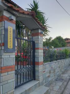 a black fence with a sign on top of it at Chriselia House in Nea Roda