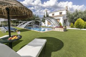 a garden with a swimming pool and a house at Cortijo el Zafiro in Montefrío