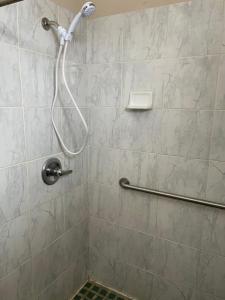 a shower with a hose in a bathroom at American Motor Inn - Rock Island in Rock Island