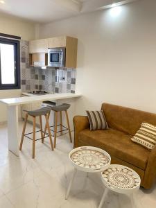 a living room with a couch and a kitchen at Résidence Cap Sud in Dakar