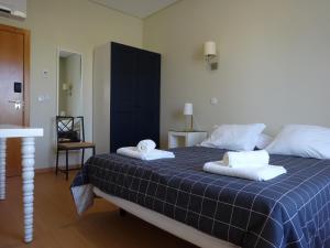 1 dormitorio con 1 cama con 2 toallas en Green & Sea Comporta Retreat en Comporta