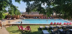 a group of people sitting around a swimming pool at Camping Les Lavandes in Darbres