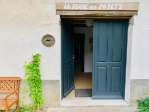 una puerta verde de un edificio con un cartel encima en La Ferme des Potets, en Fresse