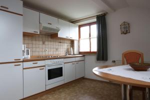 una pequeña cocina con armarios blancos y una mesa en Ferienwohnung Sobotta, en Bad Reichenhall