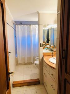 ein Badezimmer mit zwei Waschbecken und einer Dusche sowie zwei Toiletten. in der Unterkunft La Noemi in Esquel