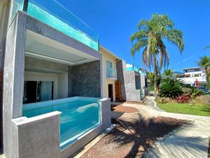 a house with a swimming pool in front of it at Pousada Villa del Sol in Paraty